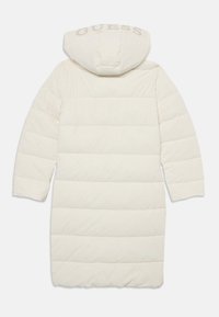 Pufjakas gaismi krēmkrāsā, ar kapuci, horizontālu quilted dizainu un "GUESS" logotipu aizmugurē subtilā bēša krāsā.