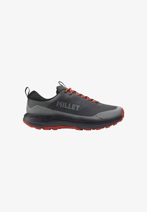 Chaussure de randonnée gris foncé et noire avec des lacets et une semelle rouges, logo "MILLET" sur le côté, et boucles pour tirer au talon et à la languette.