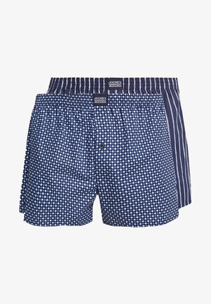 Twee paren herenboxers: één met blauwe ruitpatronen en één met blauwe verticale strepen. Beide hebben elastische taillebanden en knopen aan de voorkant.