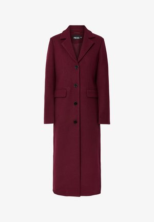 Lange bordeauxrode jas gemaakt van een wolmix, voorzien van een reverskraag, zes zwarte knopen en twee voorzakken. Soepele textuur en een getailleerde pasvorm.