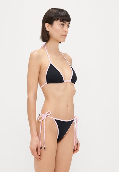Bikini negro con ribete rosa, que presenta un sujetador triangular y una parte de abajo de lazo. El material parece suave, con detalles de diseño minimalistas.