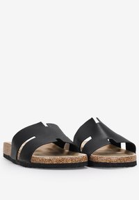 Black slide sandals with a cork footbed, featuring cut-out straps and a textured surface for improved grip and comfort.