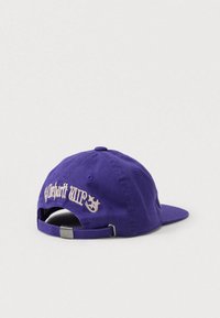 Gorra de béisbol púrpura con correa ajustable y texto bordado en blanco junto con estrellas en la parte trasera, colocada sobre una superficie blanca lisa.