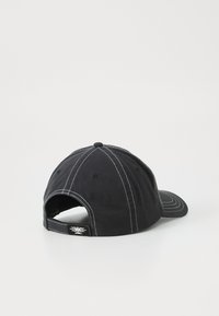 Svart baseballcaps med kontrasterande vit sömnad, böjd skärm och en justerbar baksats med en logotyp. Mjuk tygtextur.