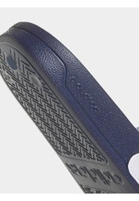 Suela de sandalia de goma azul oscura con patrón de agarre texturizado y detalle en relieve de "cloudfoam". Superficie suave con diseño de bordes curvados.