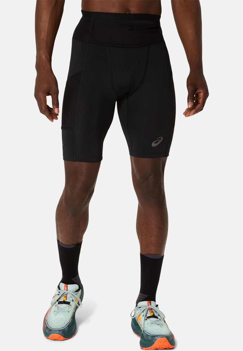 Shorts de sport noirs avec une texture lisse, dotés d'une taille haute et d'un design à panneaux cousus. Accent logo subtil sur le bas de la jambe.