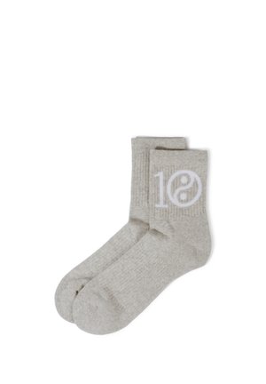 Chaussettes crew côtelées gris clair avec "10" blanc et symbole yin-yang sur le côté, posées à plat sur un fond blanc.