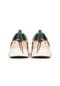 Beige Sneakers mit schwarzen und grünen Akzenten, ausgestattet mit einem strukturierten Obermaterial, runden Schnürsenkeln im gestreiften Muster und einer gepolsterten Ferse für zusätzlichen Komfort.