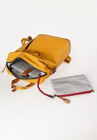 Zaino giallo con dettagli in pelle marrone, chiusura con zip e interno grigio. Include una piccola borsa grigia con zip rossa e tracolla.