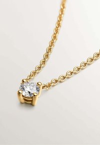Collar de cadena de oro con una gema clara redonda engastada en un soporte de cuatro garras, con un diseño de cadena entrelazada y acabado pulido.