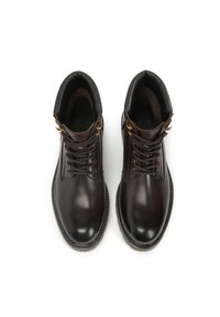 Botine din piele maro, până la gleznă, cu un finisaj neted, vârf rotund, ochiuri din metal și șireturi întunecate. Partea superioară căptușită pentru confort.