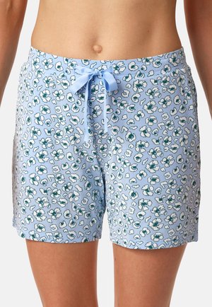 Hellblaue Shorts mit floralem Muster in Weiß und Dunkelgrün, mit einer gebundenen Satin-Schleife an der Taille, getragen von einer Person, die von der Taille bis zur Mitte des Oberschenkels gezeigt wird.