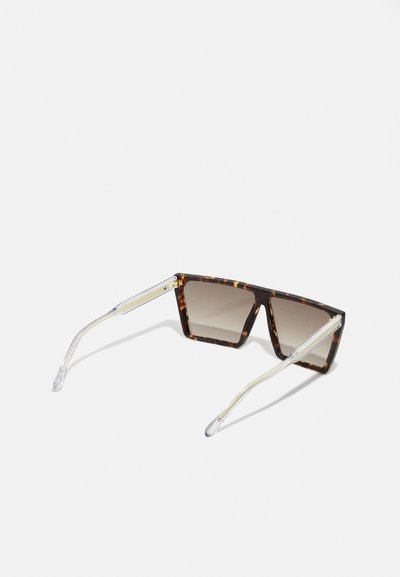 Schildpadbril met gradient lenzen, vierkante vorm en transparante pootjes met metallic accenten, gepresenteerd op een witte achtergrond.