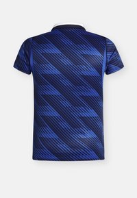 Tricou polo bleumarin cu mâneci scurte, cu un model geometric în dungi diagonale albastru deschis și guler alb, văzut din spate.