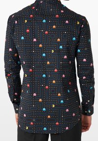 Zwarte shirt met een Pac-Man arcade gamedesign, featuring kleurrijke geesten, blauwe lijnen en witte stippen, gemaakt van een gladde stof.
