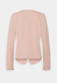 Veste ajustée à manches longues de couleur rose clair, avec un ourlet légèrement arrondi, un tissu texturé et des coutures nettes. Vue de dos montrant l'absence de fermetures.