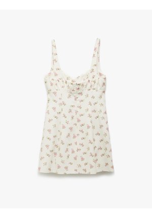 Vestido sin mangas de tela crema claro con estampado floral, que presenta flores en tonos rosados y verdes, un corpiño fruncido y un corte relajado.