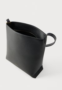 Zwarte leren shopper met een gestructureerde afwerking, open bovenkant en een binnenvak met rits. Voorzien van een zijhandvat voor gemakkelijk dragen.