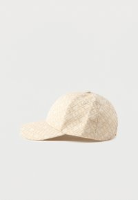 Casquette de baseball beige avec un motif géométrique léger beige sur toute sa surface et une visière courbée, placée sur une surface blanche.