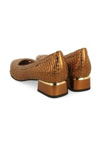 Ballerines tissées en bronze avec un bout rond et un petit talon carré, ornées d'un accent doré. Surface texturée avec un éclat subtil.