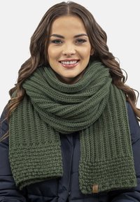 Écharpe en tricot verte avec une texture côtelée, une large section aux extrémités et un détail d'étiquette. Offre chaleur et couvre la zone du cou.