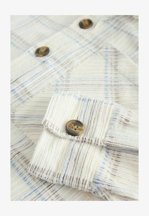 Camicia a quadri di colore chiaro con strisce verticali e orizzontali in blu e marrone, in tessuto testurizzato e con un bottone rotondo marrone.