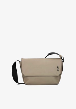 Beige crossbody bag made of smooth material, featuring a fold-over design, a black strap, and a printed logo on the front.