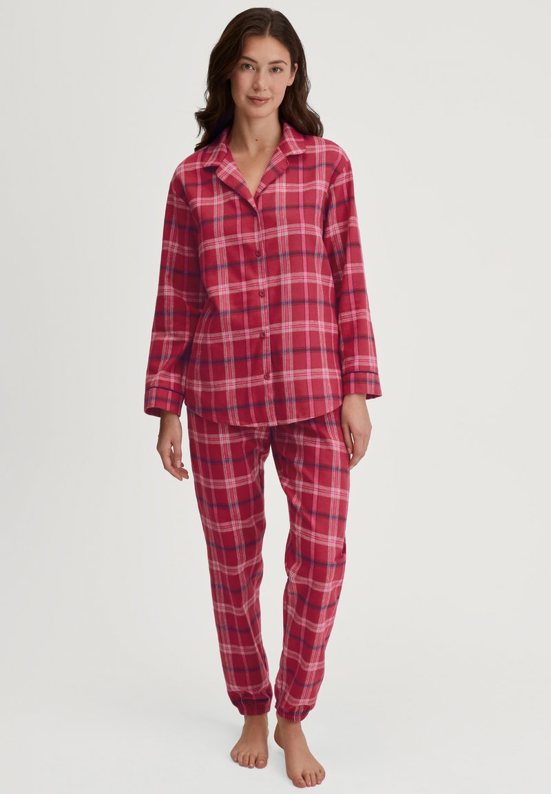 Rode geruite flanellen pyjama set met een knoopsluiting bovenstuk met lange mouwen en bijpassende broek met elastische boorden, met de nadruk op een zachte, comfortabele textuur.
