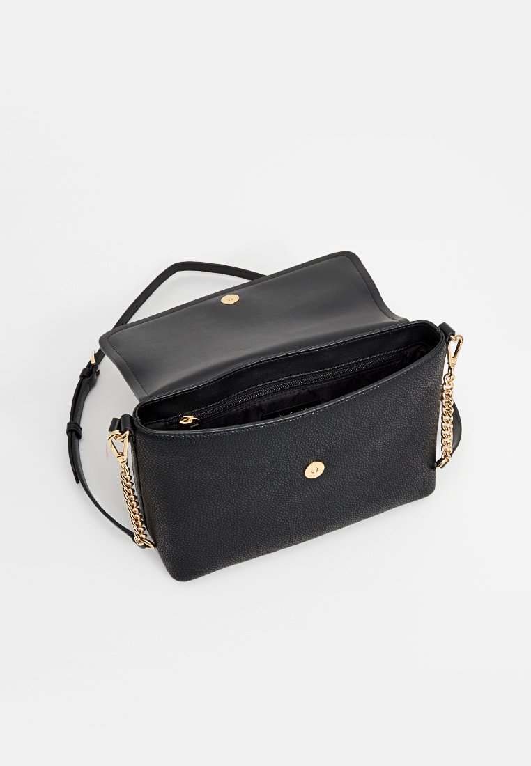 Bolso de mano de cuero negro con superficie texturizada, herrajes dorados, una cadena como correa y un bolsillo interior con cremallera. Diseño abierto y espacioso.
