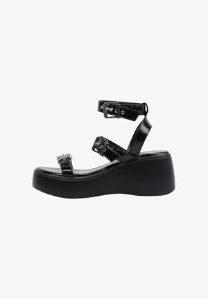 Sandale plateforme noire avec trois brides réglables à boucle et une semelle épaisse, vue de profil sur fond blanc.