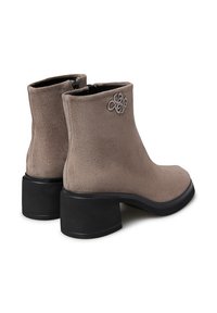 Stivali alla caviglia in suede grigio con tacco a blocco nero, dotati di un accento decorativo del logo sul lato e una cerniera sul retro per una facile vestibilità.