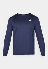 Pitkähihaisen tummansinisen urheilupaidan materiaali on sileä ja kevyt. Paidassa on pyöreä kaula-aukko ja rintataskussa pieni valkoinen logo.