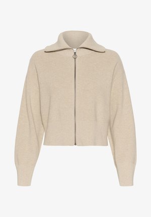 Beige ribatatud kudum, millel on kõrge krae, eesne pael ja langetatud õlad; omaduseks on lühike pikkus ja laiad mansetid.