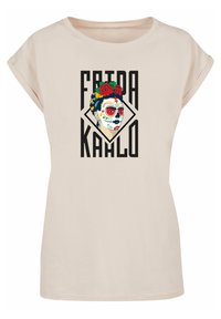 Kortærmet, lys beige t-shirt med et grafisk print af et kvindansigt med farverig ansigtsmaling og roser, omgivet af sort tekst.