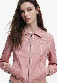 Rosa Bomberjacke aus synthetischem Material mit einem Reißverschluss vorne, gerippten Bündchen und zwei Seitentaschen. Verfügt über einen Kragen und genähte Details.