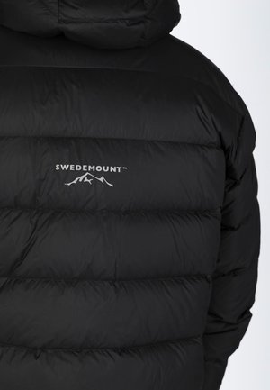 Schwarze Pufferjacke mit gestepptem Design, ausgestattet mit einer Kapuze und dem "SWEDEMOUNT"-Logo über einer weißen Berggrafik.