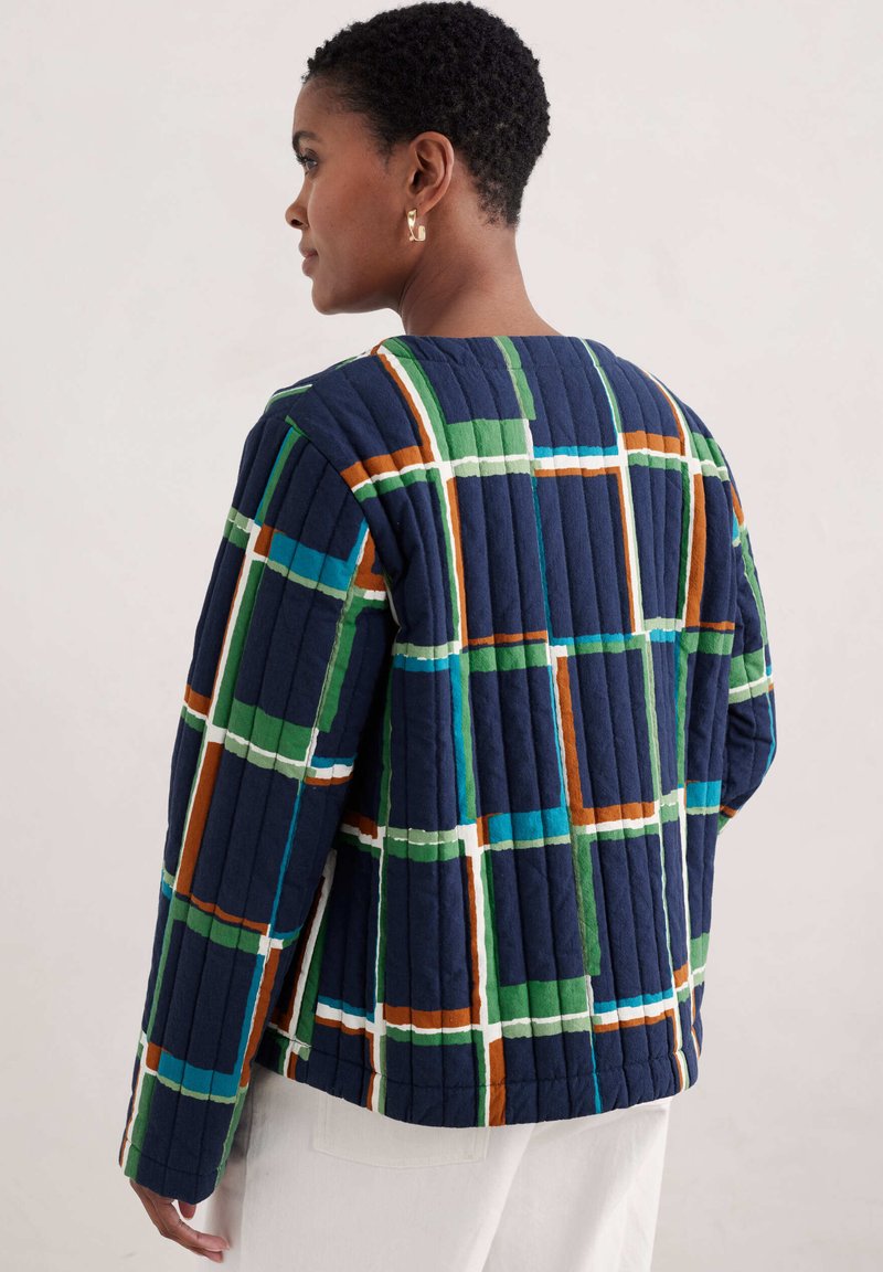 Pikowany granatowy kurtka z wielokolorowym geometrycznym wzorem w odcieniach zieleni, niebieskiego, pomarańczowego i białego, z okrągłym dekoltem i długimi rękawami.