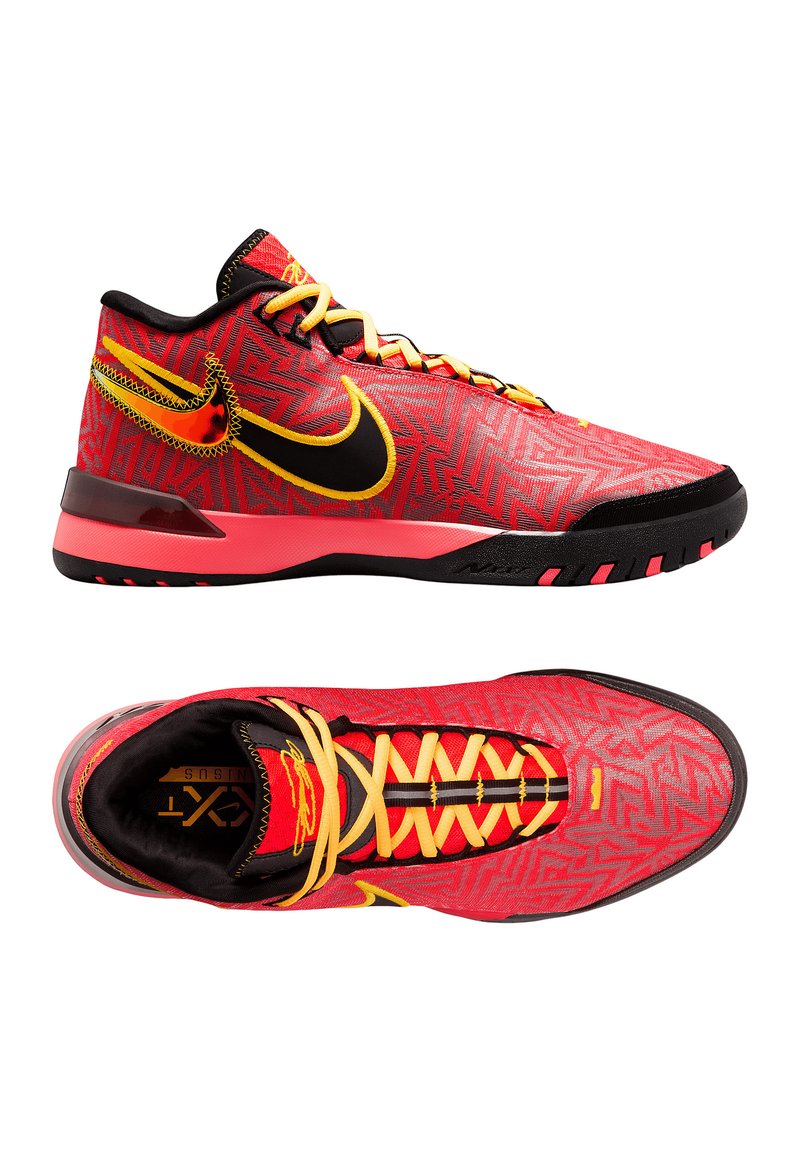 Chaussures de sport rouges et noires avec un motif texturé, dotées de lacets jaunes et d'un célèbre swoosh noir de Nike. Semelle en caoutchouc et col rembourré.