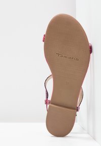 Sole růžové sandálové obuvi na řemínky s texturovanou hnědou gumovou podrážkou, viditelné logo značky "Tamaris" a velikost 37.