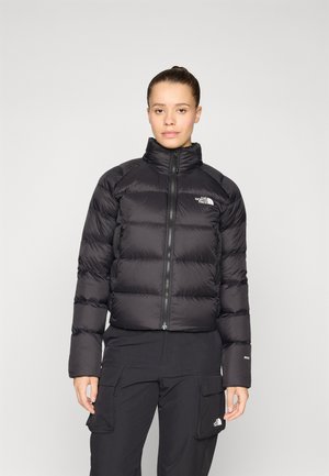 Svart puffjakke med høy krage, horisontale sømmer og glidelås. Har The North Face-logoen på brystet.