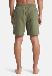 Shorts de bain vert olive avec taille élastique, poches latérales et une poche arrière unique, présentant une texture lisse sans motifs visibles.