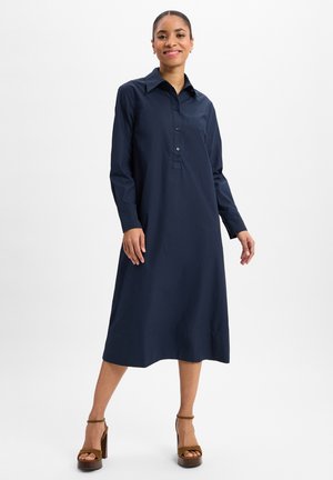 Marineblaues Hemdblusenkleid mit langen Ärmeln, Kragen und lockerer Passform, aus glattem Stoff, in mittellanger Länge bis zur Wade.