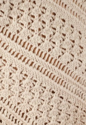 Woven textile featuring a cream color with intricate openwork patterns, textured and layered with a fine brown background.