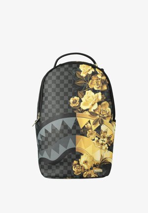 Zaino con motivo a quadri nero e grigio a sinistra, disegno floreale giallo a destra e forme frastagliate stilizzate sulla parte anteriore.