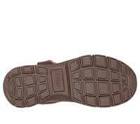 Semelle de chaussure en caoutchouc brun présentant un motif texturé avec des rainures profondes et des sections surélevées pour une traction et une stabilité accrues.