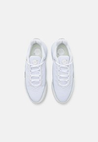 Bílé sportovní boty s síťovaným svrškem, kulatými tkaničkami, polstrovaným límcem a gumovou podešví s texturovanými detaily.