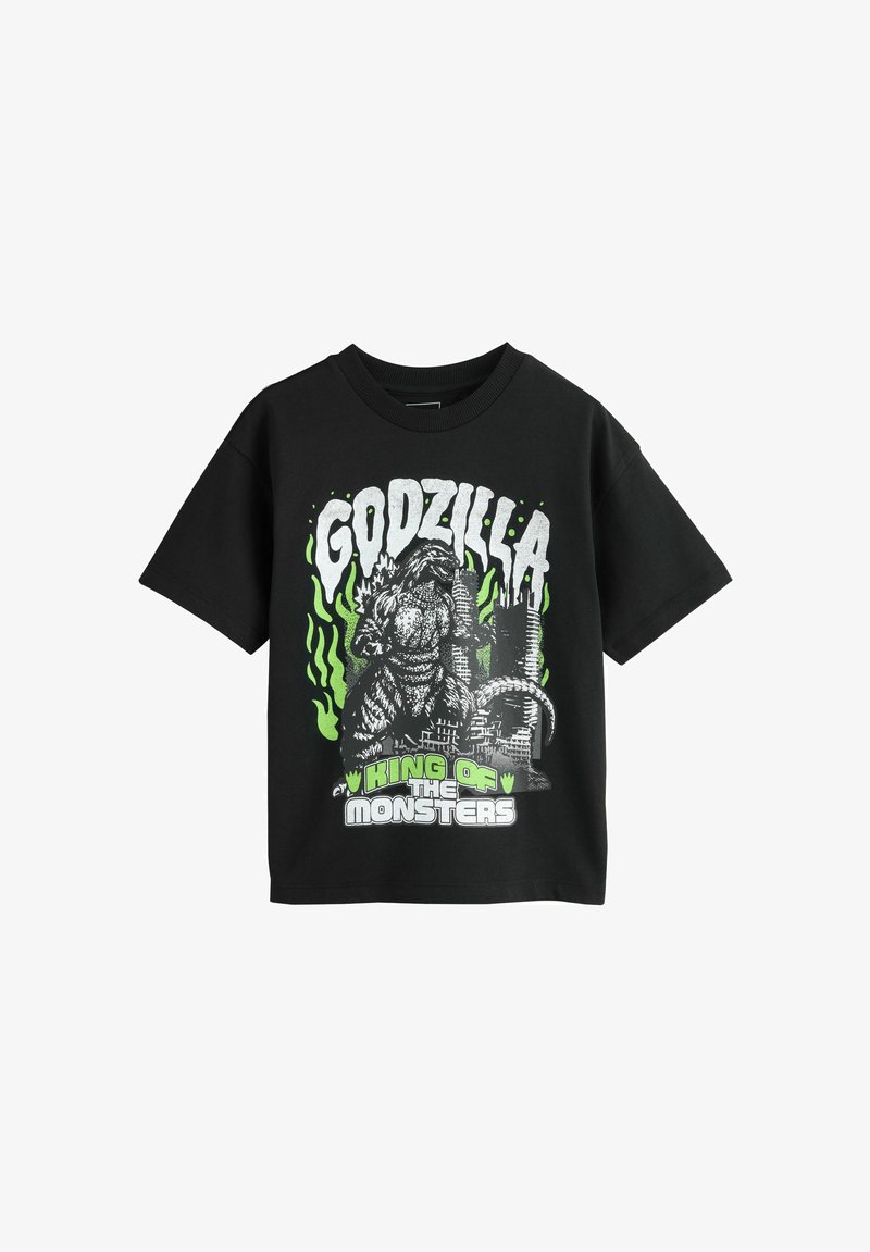 Fekete póló Godzilla grafikával, zöld lángokkal, városi romokkal és "KING OF THE MONSTERS" felirattal fehér és zöld betűkkel.
