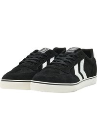 Czarne zamszowe sneakersy z białymi paskami, z teksturowaną cholewką, okrągłym noskiem i miękkimi sznurowadłami, osadzone na białej gumowej podeszwie.