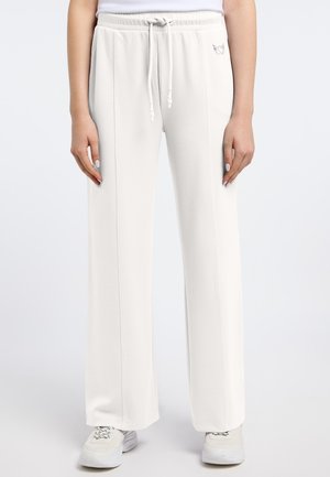 White sweatpants with a drawstring waistband, side seam details, and a small embroidered accent on the hip. Fabric appears soft and textured.