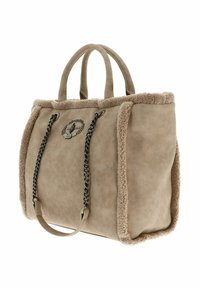 Sac cabas beige avec bordure en fausse fourrure, équipé de deux poignées, un patch logo décoratif et un accent en chaîne sur le devant. Texture lisse.